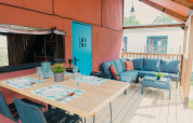 Outdoor dining and lounge area at Wander Lodge at Holiday park De Boshoek in the Netherlands, blue door.