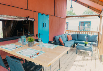 Area pranzo e salotto all'aperto alla Wander Lodge di Holiday park De Boshoek nei Paesi Bassi, porta blu.
