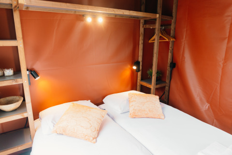Chambre chaleureuse à Wander Lodge du parc De Boshoek aux Pays-Bas, deux lits jumeaux et déco en bois.