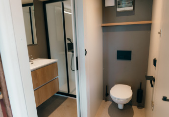 Modern bathroom and toilet at Wander Lodge, Holiday park De Boshoek, Netherlands, with minimalist interior.