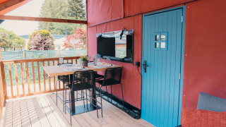 Buiten eetgedeelte op het terras van Wander Lodge met een blauwe deur en gezellig gedekte tafel.