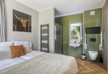 Modern bedroom at Veluwehoeve, Bospark Ede, Netherlands, showing double bed, open en-suite and decor.