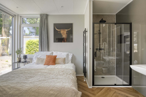 Bright bedroom at Veluwehoeve, Bospark Ede, with double bed, modern shower, and large windows.