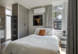 Dormitorio moderno con cama doble en Veluwehoeve, Bospark Ede, Países Bajos, con ventanas y decoración.
