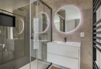Bagno moderno nella Veluwehoeve a Bospark Ede, Paesi Bassi, con specchio tondo e cabina doccia.