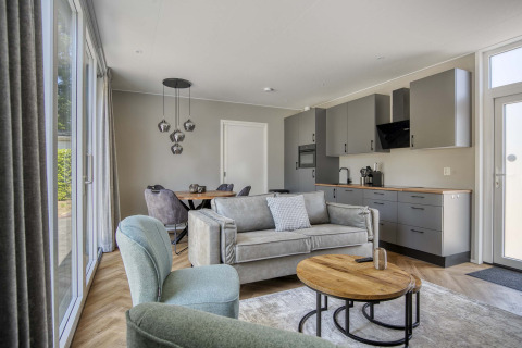 Lodge moderne Veluwehoeve à Bospark Ede, Pays-Bas, avec salon ouvert, cuisine et grandes fenêtres.