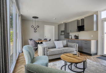 Moderna lodge Veluwehoeve a Bospark Ede, Paesi Bassi, con soggiorno luminoso, cucina e ampie vetrate.