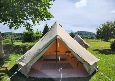 Safaritent genaamd Belltent op Camp Diekirch in Luxemburg, omgeven door groene velden en natuur.