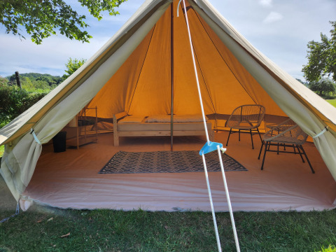 Indgang til Belltent safari-telt på Camp Diekirch i Luxembourg, møbleret med seng og stole.