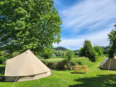 Safari telt Belltent ved Camp Diekirch i Luxembourg på en solrig dag med grønne marker og træer.