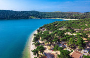 Aerial view of Camping Arena One 99 Glamping in Istria, Croatia, with pine trees, beach, and blue sea.