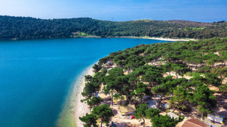 Luchtfoto van Camping Arena One 99 Glamping in Istrië, Kroatië, met bos, strand en blauw water.