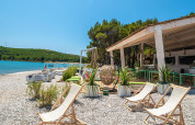Relaxing beach area at Camping Arena One 99 Glamping in Istria, Croatia, with deck chairs and a beach bar.
