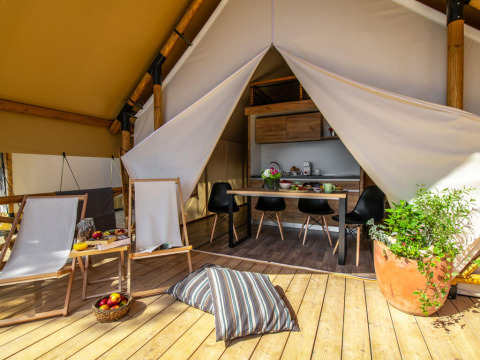 Tenda safari con terrazza in legno e zona pranzo al Camping Arena One 99 Glamping in Croazia.