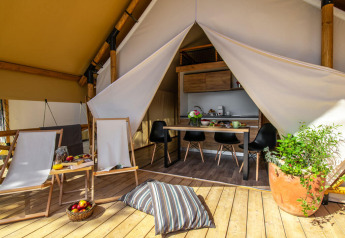 Tente safari avec terrasse en bois et coin repas au Camping Arena One 99 Glamping en Croatie.