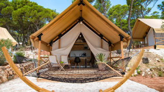 Tente safari deux chambres au Camping Arena One 99 Glamping en Croatie, terrasse avec hamac et mobilier en bois.