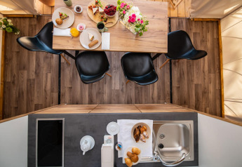 Vue du dessus de la table et cuisine dans une tente safari deux chambres au Camping Arena One 99 Glamping, Croatie.