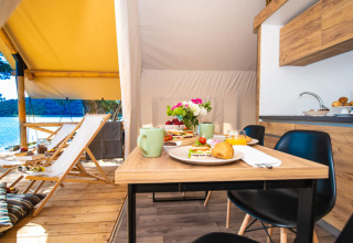 Colazione su tavolo in legno dentro una tenda glamping al Camping Arena One 99 Glamping in Istria, Croazia.