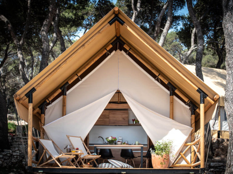 Twee slaapkamer safaritent bij Camping Arena One 99 Glamping in Kroatië, omgeven door bomen.