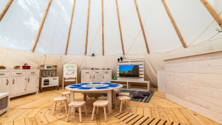 Indendørs børnelegeområde med træmøbler, borde og stole i et telt ved Camping Arena One 99 Glamping, Istrien.