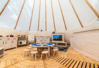 Binnen kinderspeelruimte met houten meubels, tafels en krukjes in een tent bij Arena One 99 Glamping, Istrië.