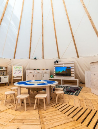 Indendørs børnelegeområde med træmøbler, borde og stole i et telt ved Camping Arena One 99 Glamping, Istrien.