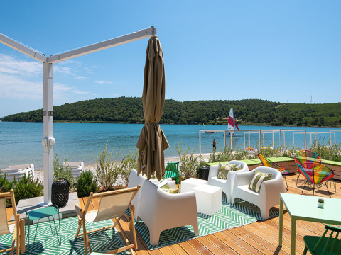 Area lounge all'aperto con arredi moderni vista mare a Camping Arena One 99 Glamping in Istria, Croazia.