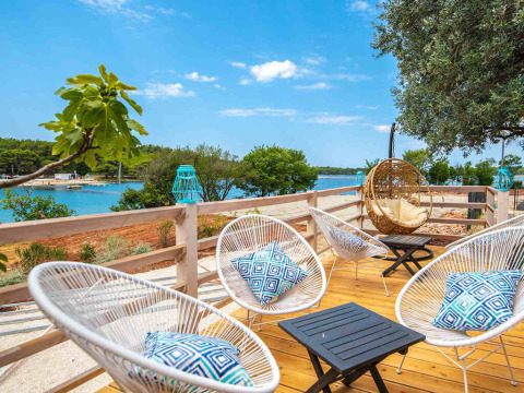 Terrasse mit stilvollen Loungemöbeln, Kissen und Blick aufs Meer im Camping Arena One 99 Glamping, Istrien.