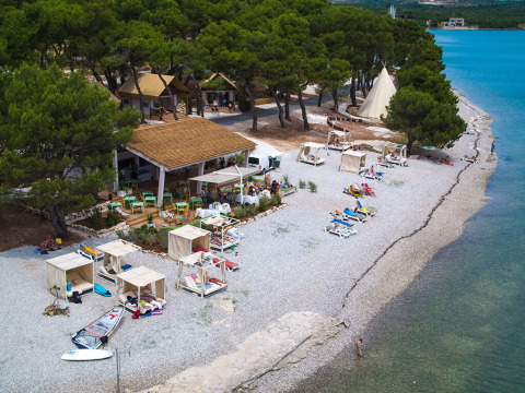 Vista aerea di Camping Arena One 99 Glamping in Istria, Croazia, con spiaggia, cabanas e mare blu.
