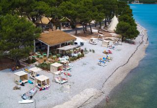 Vue aérienne de Camping Arena One 99 Glamping en Istrie, Croatie, avec plage, cabanes et mer turquoise.