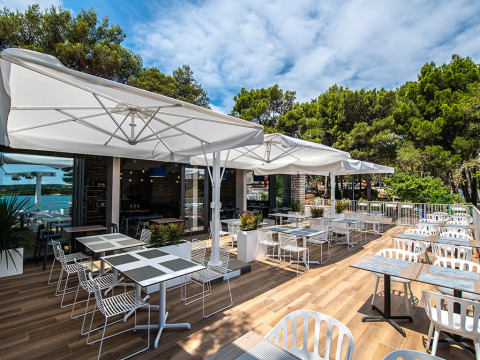 Outdoor terrace with contemporary tables and chairs at Camping Arena One 99 Glamping, Istria, Croatia, near woods.