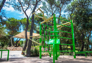 Outdoor fitness gym with green equipment surrounded by trees at Camping Arena One 99 Glamping in Istria, Croatia.