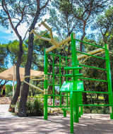 Udendørs fitnessområde med grønne fitnessredskaber under træer på Camping Arena One 99 Glamping i Istrien.