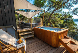 Outdoor hot tub and deck amidst forest at Camping Arena One 99 Glamping holiday park in Istria, Croatia.