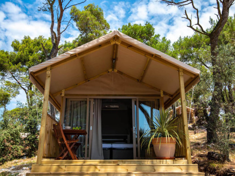 Mini Lodge safaritent op Camping Arena One 99 Glamping in Kroatië, met houten terras en buitenmeubilair.