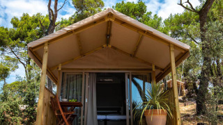 Mini Lodge safaritent op Camping Arena One 99 Glamping in Kroatië, met houten terras en buitenmeubilair.