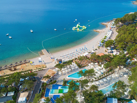 Aerial view of Valamar Camping Ježevac in Croatia, showing the beach, pools, and water playground at sea.