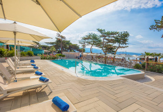 Piscina exterior con tumbonas y sombrillas en Valamar Camping Ježevac, Primorje-Gorski Kotar, Croacia.