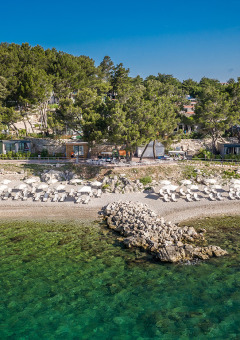Valamar Camping Ježevac en Primorje-Gorski Kotar, Croacia, con sombrillas y playa de agua cristalina.