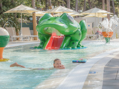Bambino che gioca in piscina con scivolo a forma di rana al Valamar Camping Ježevac, Primorje-Gorski Kotar, Croazia.
