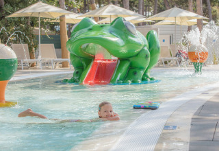 Kind spielt im Pool mit Froschrutsche im Valamar Camping Ježevac, Region Primorje-Gorski Kotar, Kroatien.