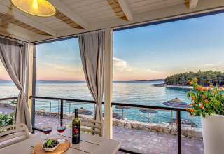 Vista dalla terrazza con vino e olive sul tavolo, affacciata sul mare al Valamar Camping Ježevac, Croazia.