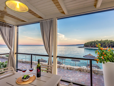 Vista desde la terraza con vino y aceitunas en la mesa, vista al mar en Valamar Camping Ježevac, Croacia.