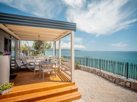 Terrasse des Lungomare Chalet mit spektakulärem Meerblick, Liegestühlen und Sitzbereich im Freien.