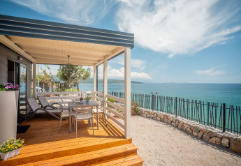 Terrasse des Lungomare Chalet mit spektakulärem Meerblick, Liegestühlen und Sitzbereich im Freien.