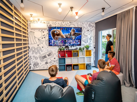 Adolescentes juegan videojuegos en una sala moderna en Valamar Camping Ježevac, Croacia.