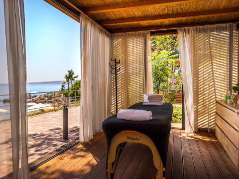 Lys massagekabine med gardiner, wellnessbænk og udsigt over havet på Valamar Camping Ježevac i Kroatien.