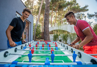 Two young men play foosball outdoors at Valamar Camping Ježevac holiday park in Primorje-Gorski Kotar, Croatia.