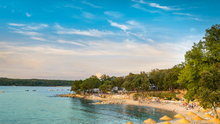 Playa con tumbonas y sombrillas en Valamar Camping Istra, un parque vacacional en Istria, Croacia.