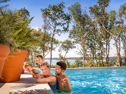 Gezin geniet van het zwembad bij Valamar Camping Istra in Istrië, Kroatië, omgeven door bomen.